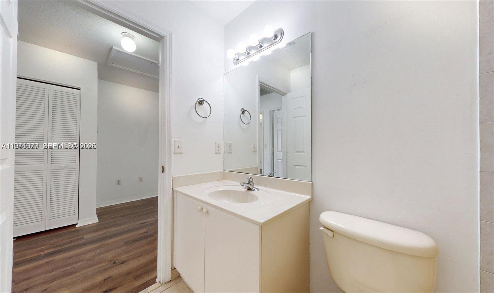 14162 Southwest 260th Street, Unit 104 Homestead, FL 33032 - Photo 30 of 35 a bathroom with a toilet sink and mirror