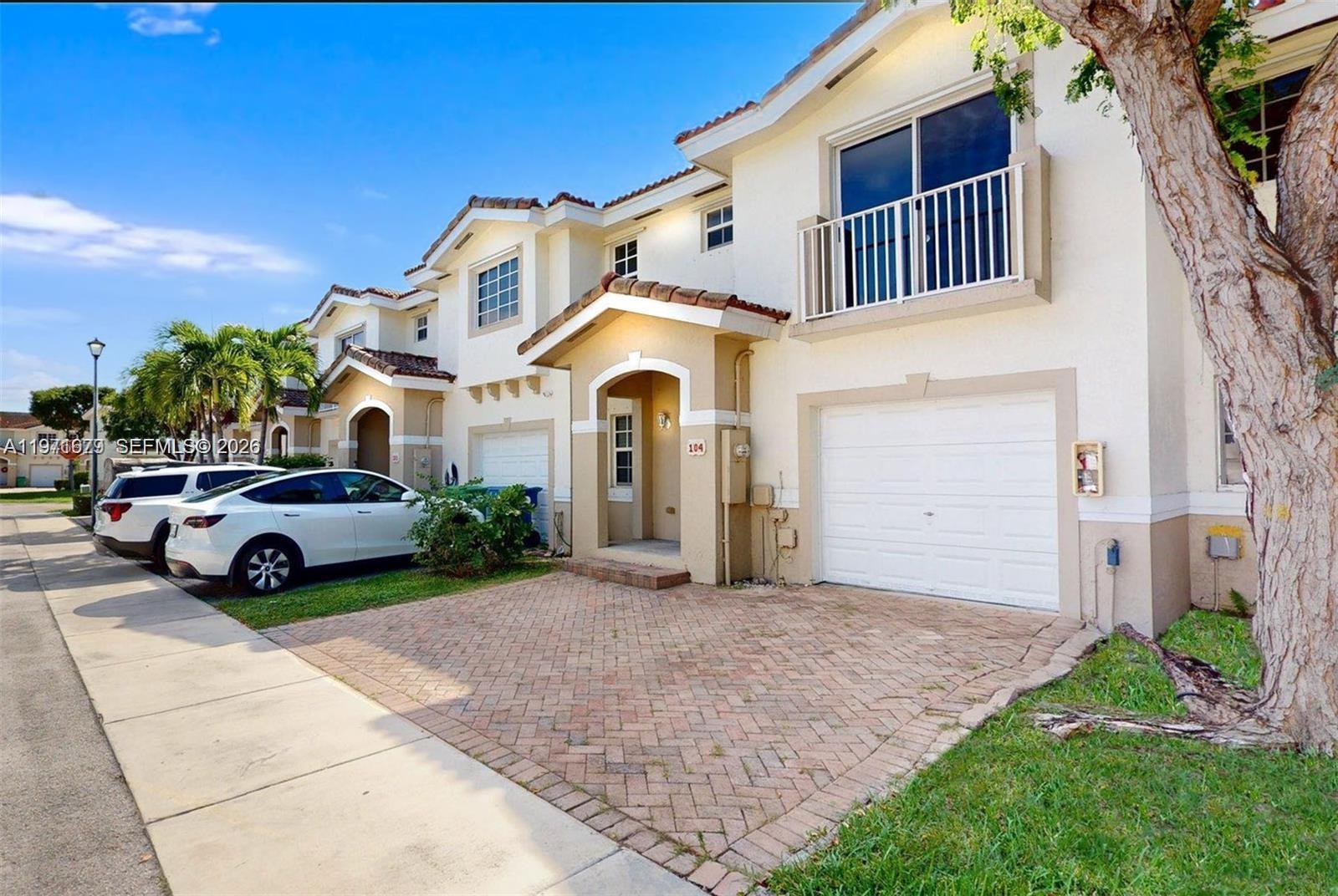14162 Southwest 260th Street, Unit 104 Homestead, FL 33032 - Photo 7 of 35 a front view of a house with a garden