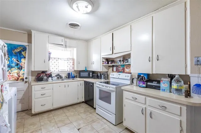 a kitchen with white cabinets and white appliances