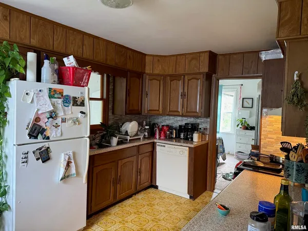 a view of a kitchen with fridge and workspace
