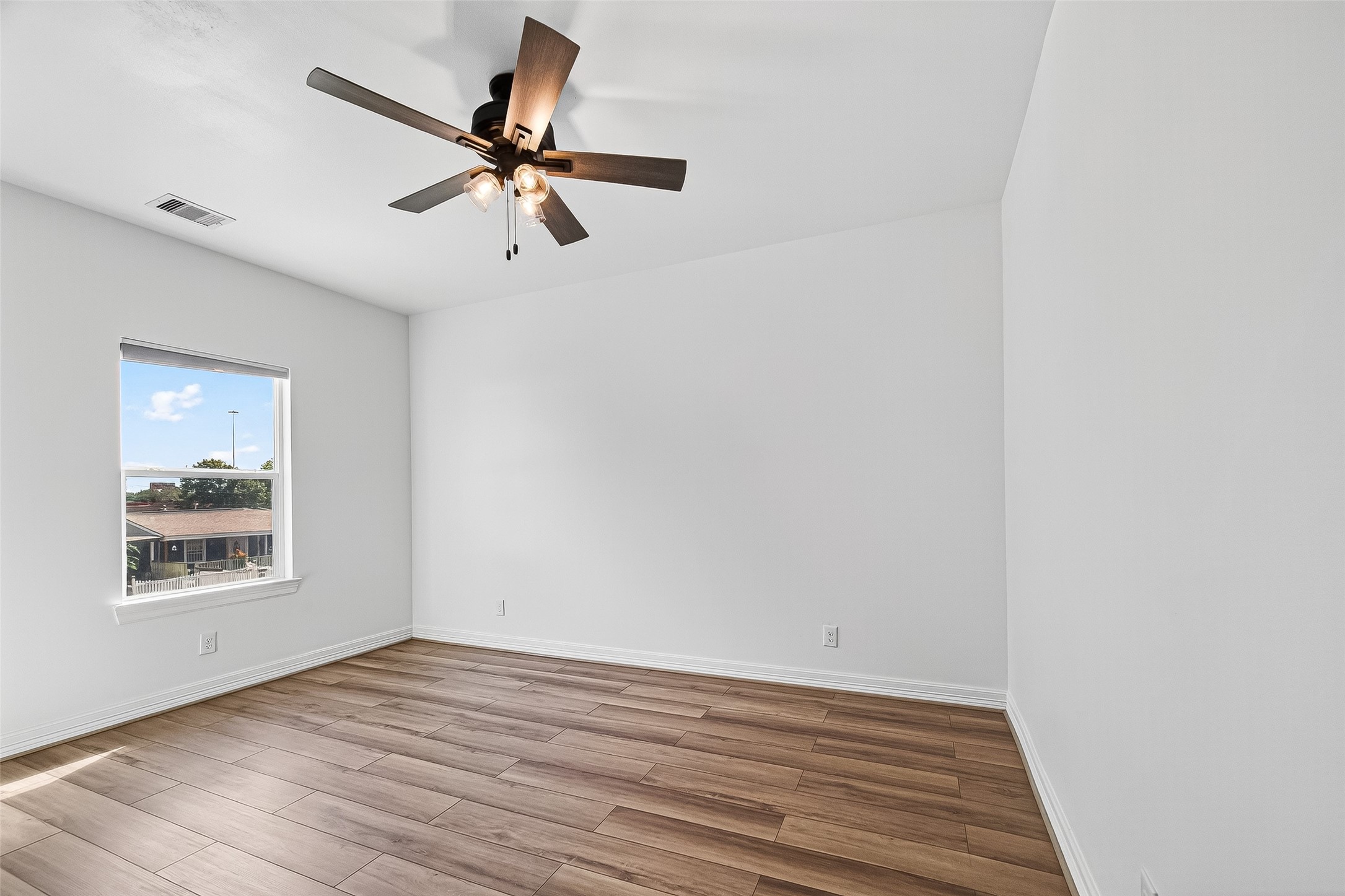 716 Zoe Street Houston, TX 77020 - Photo 30 of 39 a view of an empty room with wooden floor and a window