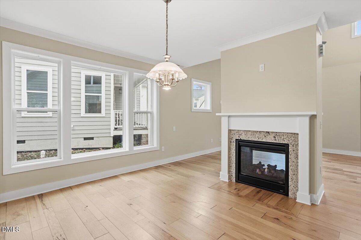 4409 Spiedie Court Raleigh, NC 27606 - Photo 12 of 33 a view of an empty room with wooden floor fireplace and a window
