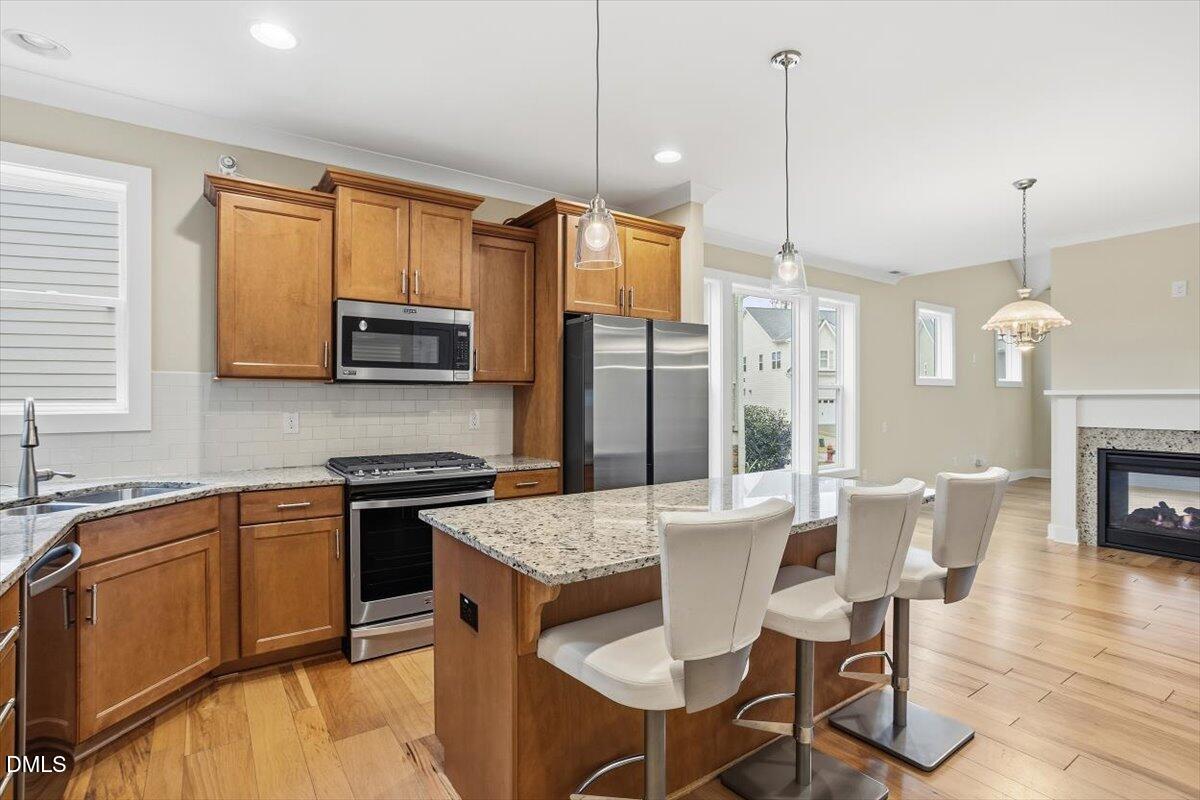 4409 Spiedie Court Raleigh, NC 27606 - Photo 13 of 33 a kitchen with stainless steel appliances granite countertop a stove a refrigerator a kitchen island a dining table and chairs