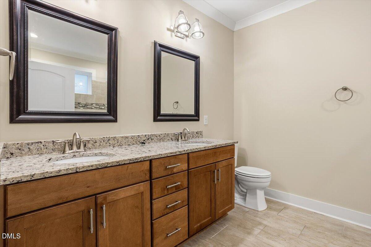 4409 Spiedie Court Raleigh, NC 27606 - Photo 18 of 33 a bathroom with a toilet sink and mirror