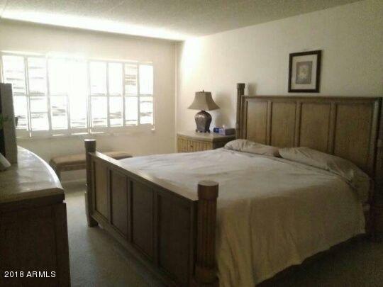 7820 East Camelback Road, Unit 310 Scottsdale, AZ 85251 - Photo 12 of 28 a bedroom with a bed and a large window