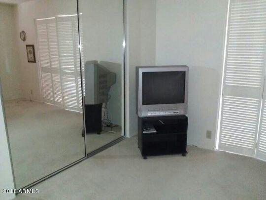 7820 East Camelback Road, Unit 310 Scottsdale, AZ 85251 - Photo 15 of 28 a living room with a flat screen tv and a walk in closet