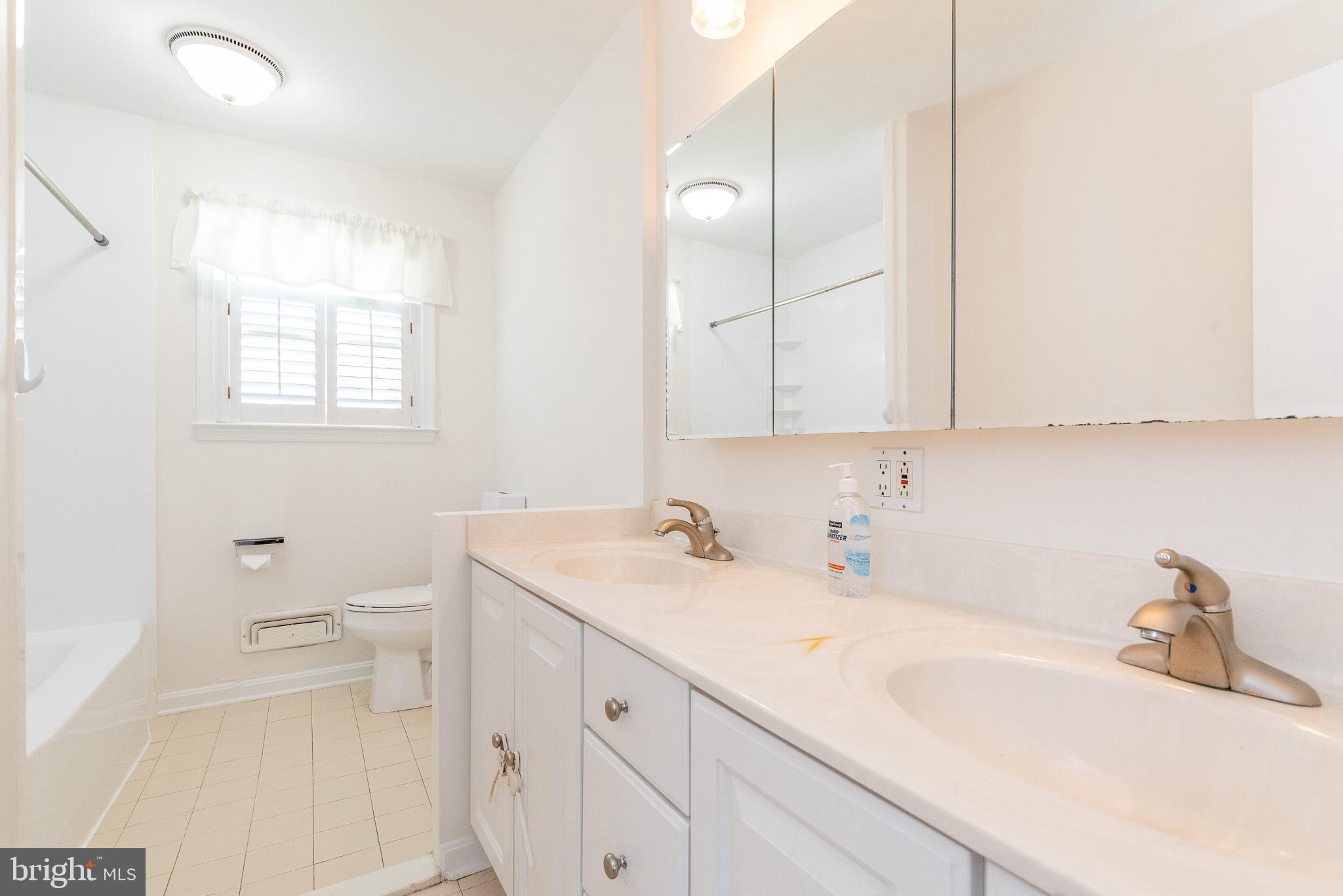 6129 Wheatland Road Baltimore, MD 21228 - Photo 13 of 48 a bathroom with a sink a toilet and a mirror