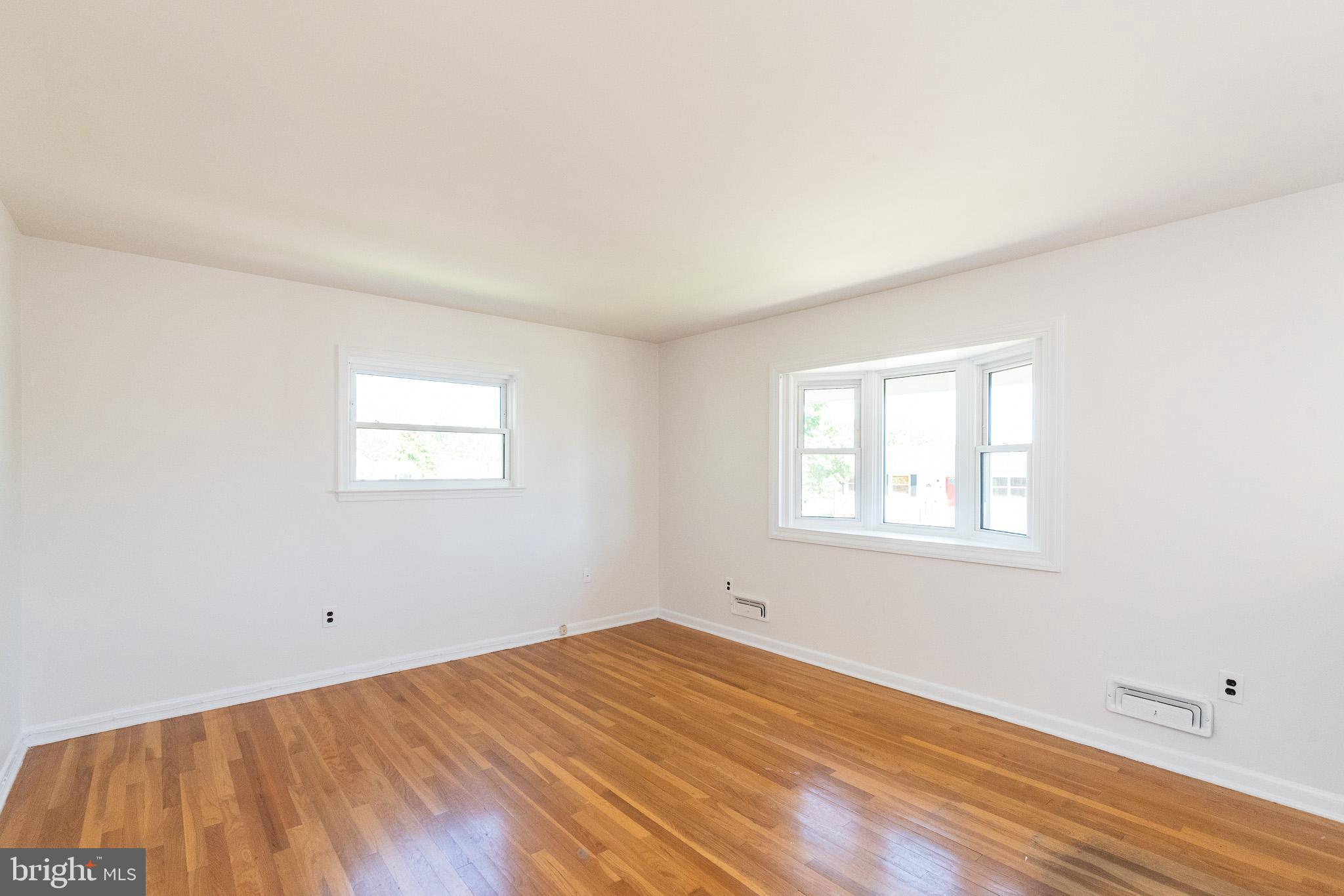 6129 Wheatland Road Baltimore, MD 21228 - Photo 14 of 48 an empty room with wooden floor and windows