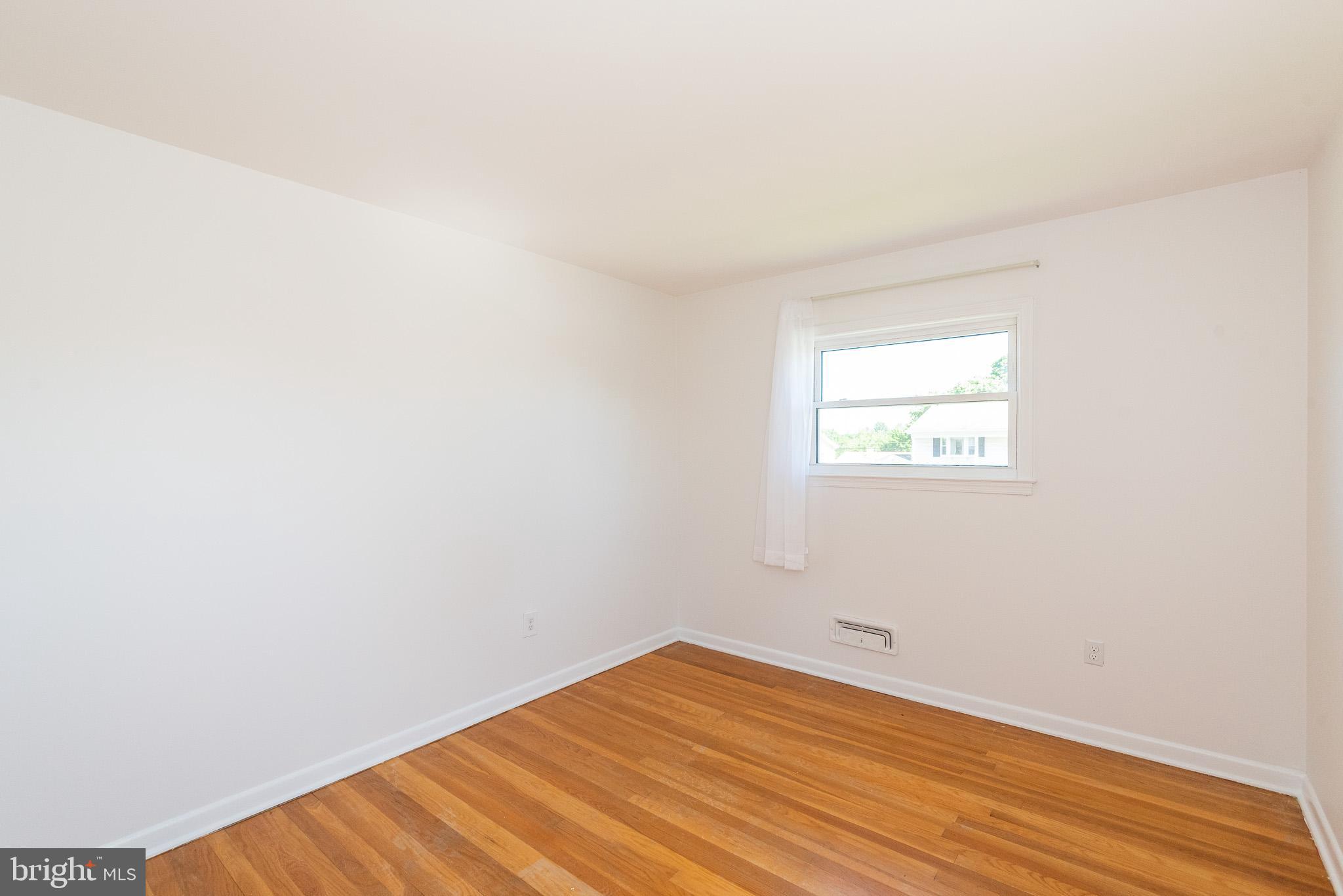 6129 Wheatland Road Baltimore, MD 21228 - Photo 23 of 48 an empty room with wooden floor and windows