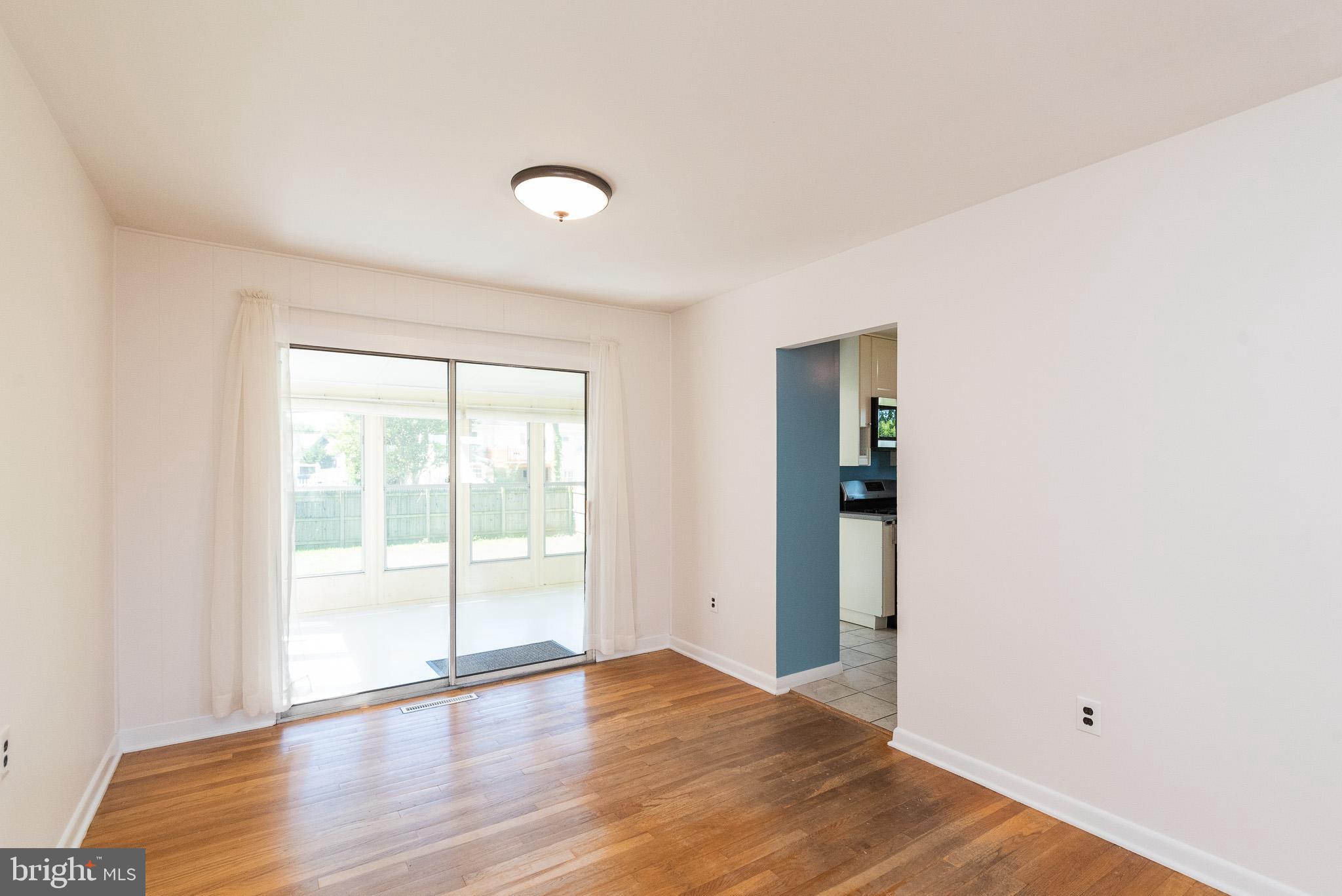 6129 Wheatland Road Baltimore, MD 21228 - Photo 27 of 48 an empty room with wooden floor and windows