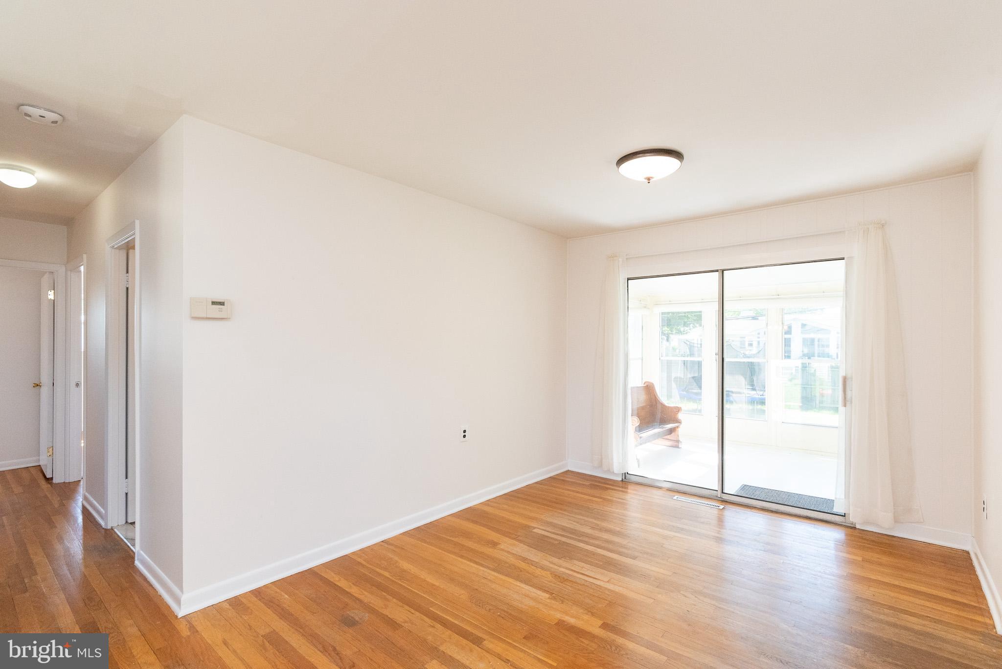 6129 Wheatland Road Baltimore, MD 21228 - Photo 30 of 48 a view of an empty room with wooden floor and a window
