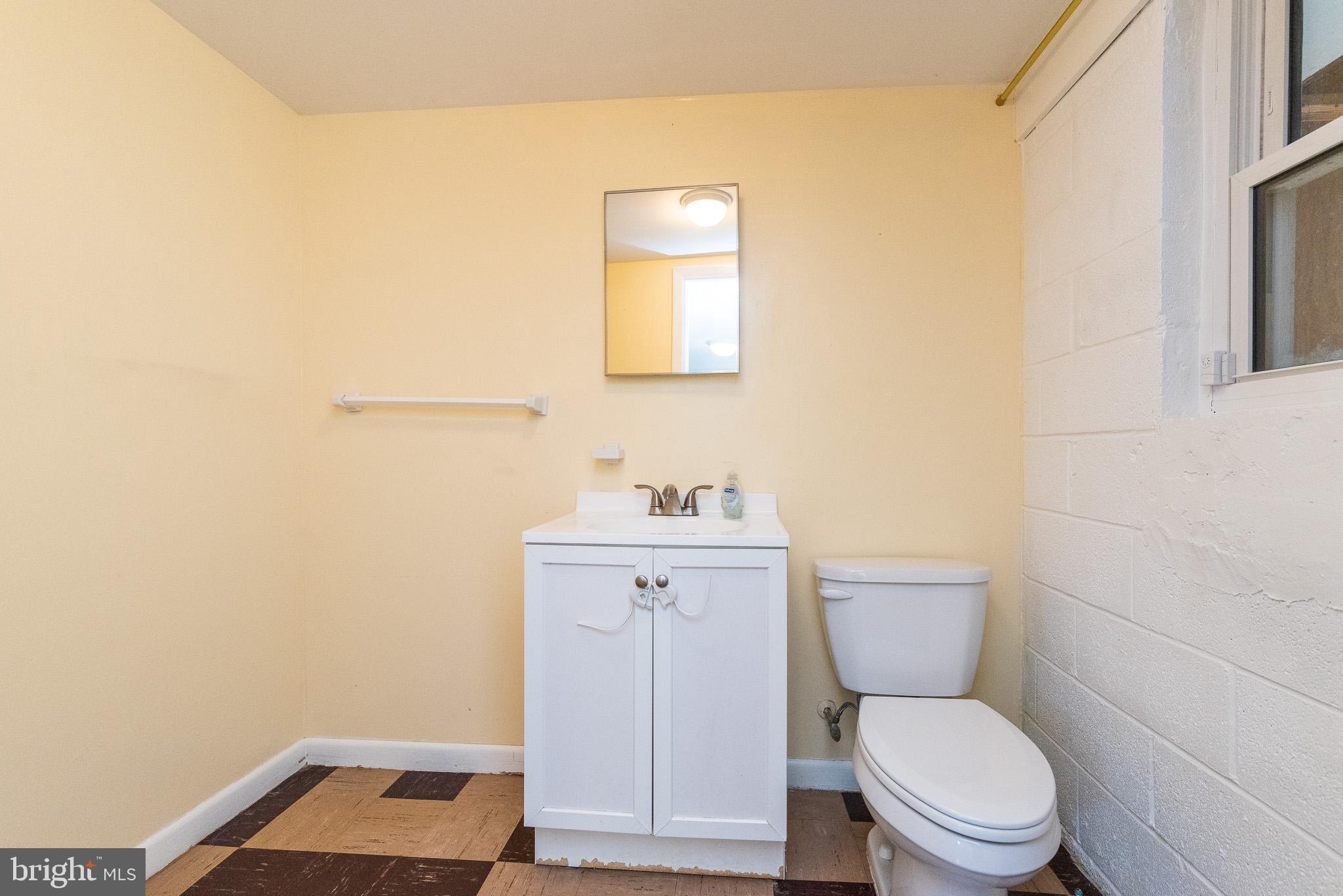 6129 Wheatland Road Baltimore, MD 21228 - Photo 40 of 48 a white toilet sitting next to a bathroom sink