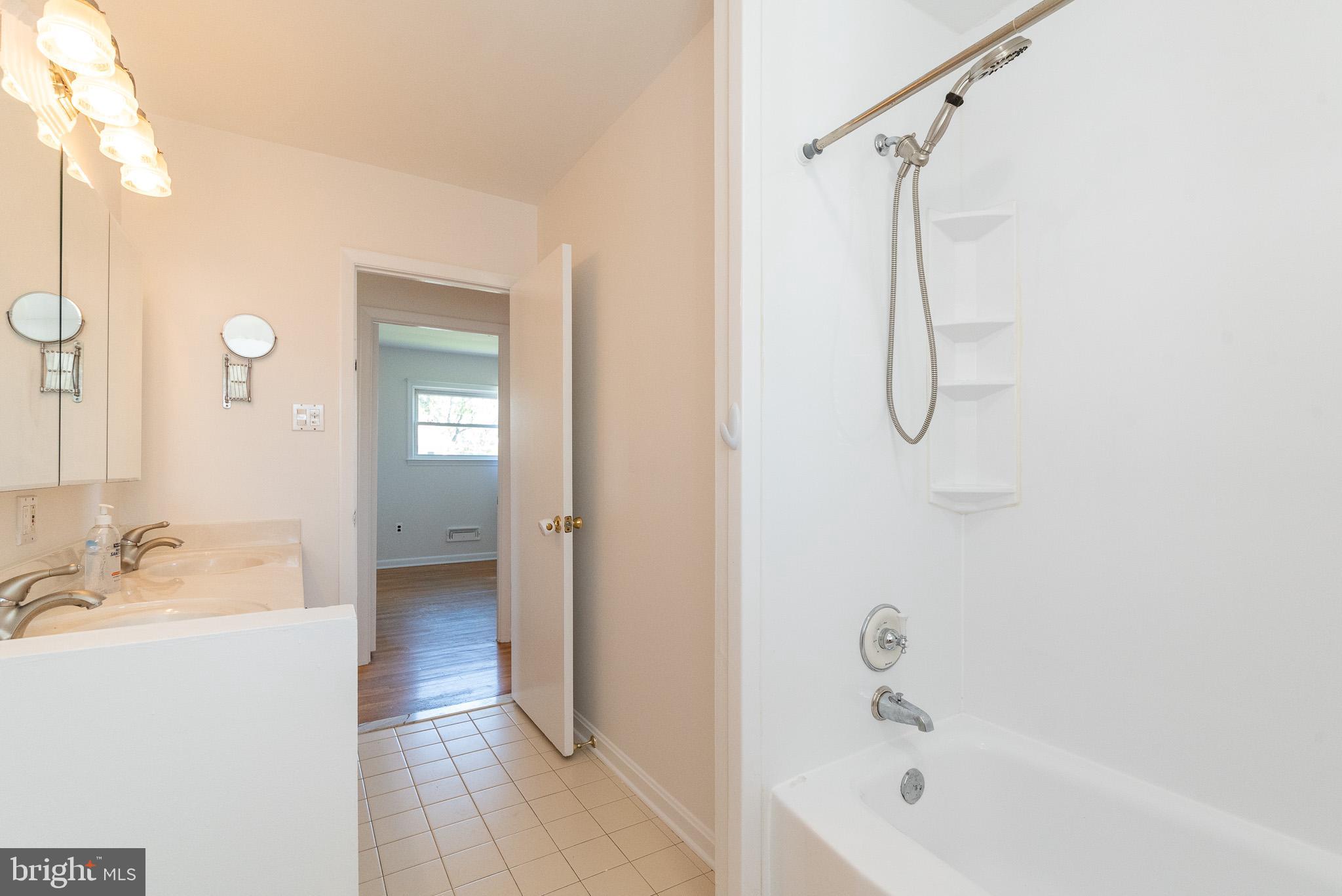 6129 Wheatland Road Baltimore, MD 21228 - Photo 41 of 48 a bathroom with a tub a sink and a mirror