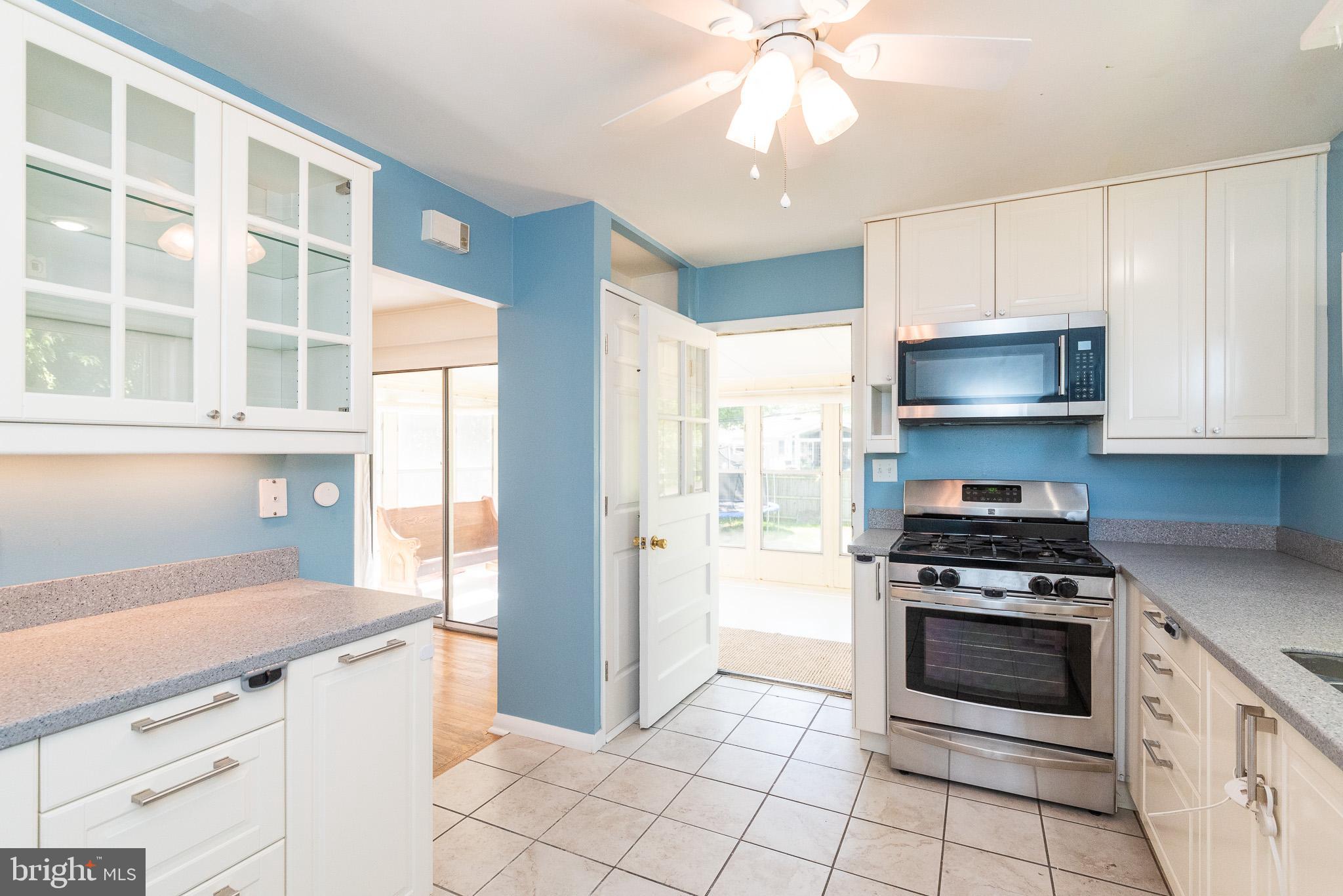 6129 Wheatland Road Baltimore, MD 21228 - Photo 6 of 48 a kitchen with granite countertop a stove a microwave and cabinets