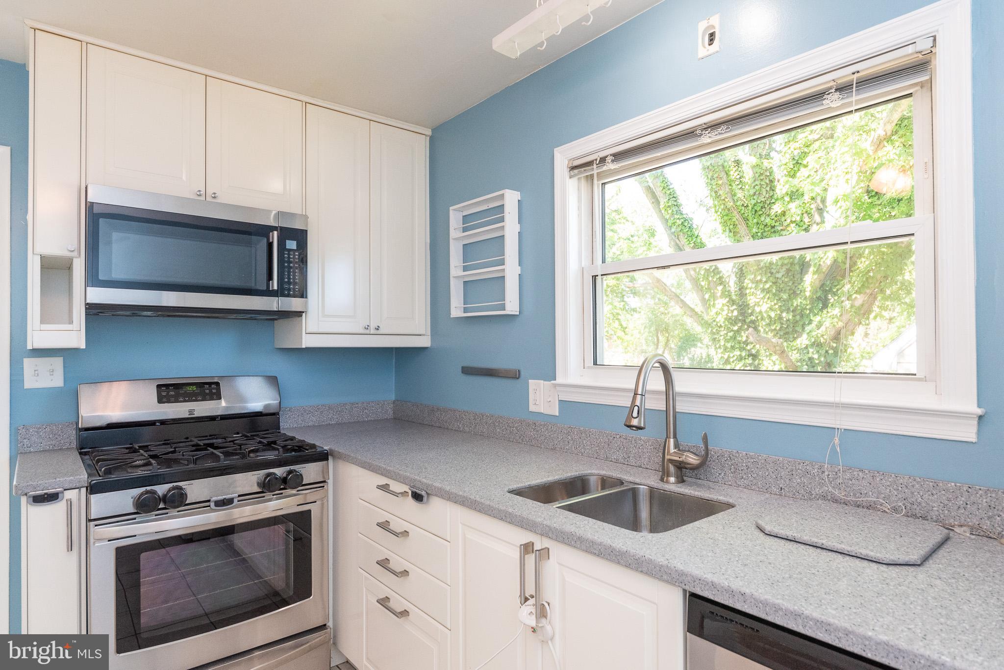6129 Wheatland Road Baltimore, MD 21228 - Photo 8 of 48 a kitchen with granite countertop a stove a sink and a microwave