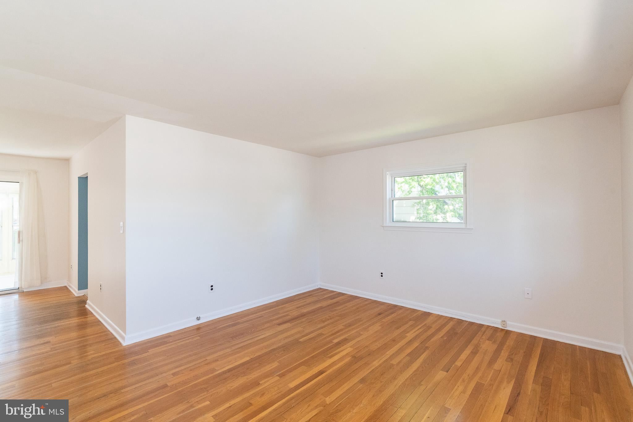 6129 Wheatland Road Baltimore, MD 21228 - Photo 10 of 48 an empty room with wooden floor and windows