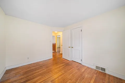 a view of an empty room and wooden floor