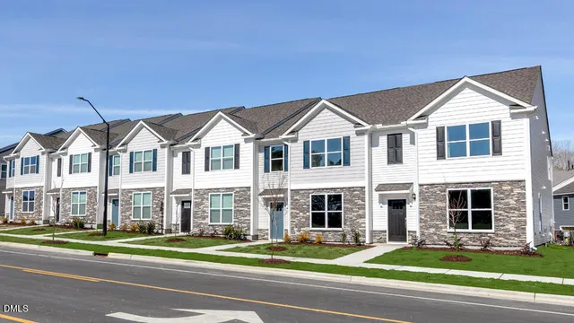 a front view of a residential houses with yard and traffic signal