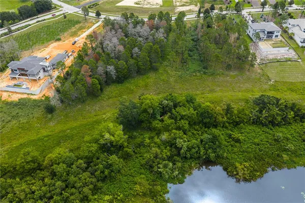 an aerial view of residential houses with outdoor space and trees