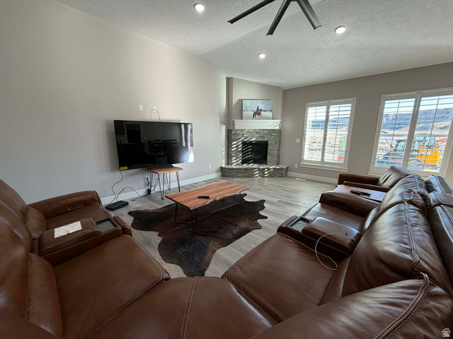 2350 North 1075 West Helper, UT 84526 - Photo 7 of 49 Living area with a textured ceiling, a fireplace, wood finished floors, lofted ceiling, and recessed lighting