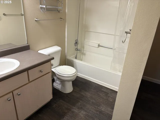 a white toilet sitting next to a bathroom sink and a shower