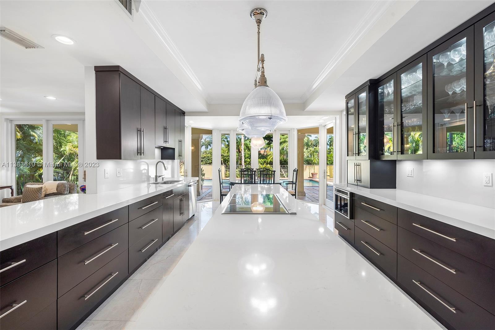 121 Gavilan Avenue Coral Gables, FL 33143 - Photo 1 of 50 a large kitchen with kitchen island granite countertop a large window in it