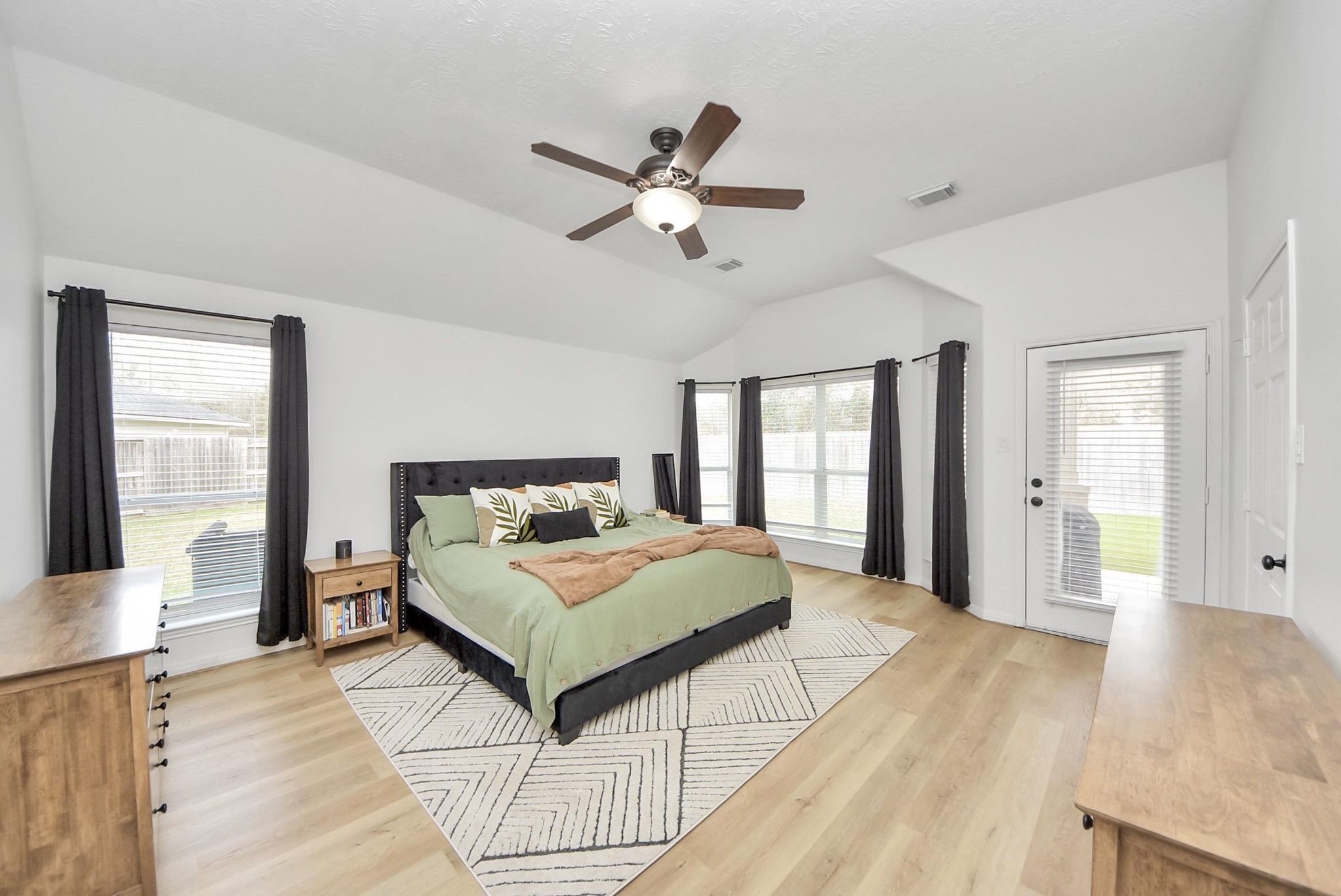 1910 Fox Path Court Katy, TX 77494 - Photo 15 of 29 a spacious bedroom with a large bed a chandelier and windows