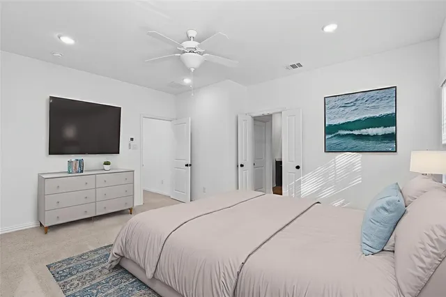 a bedroom with a large bed and a flat screen tv