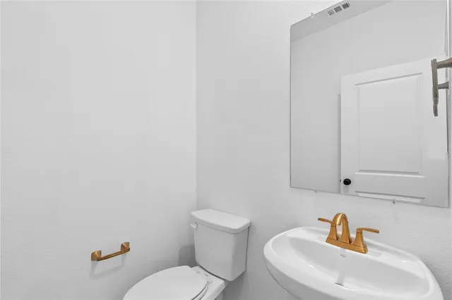 a white toilet sitting next to a bathroom sink