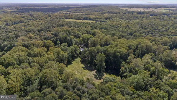 an aerial view of residential house with outdoor space and trees all around