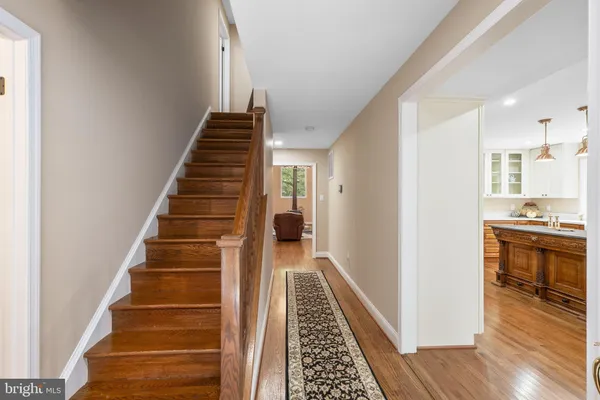 a kitchen with stainless steel appliances granite countertop wooden cabinets a sink a stove a dining table and chairs