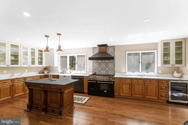 a living room with furniture a large window and wooden floor