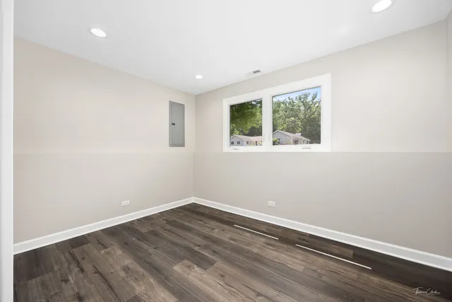 an empty room with wooden floor and window