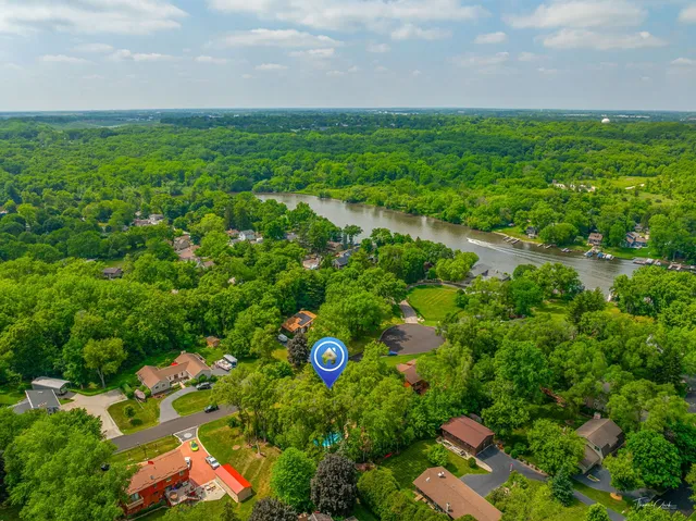 an aerial view of a house with a yard and large trees
