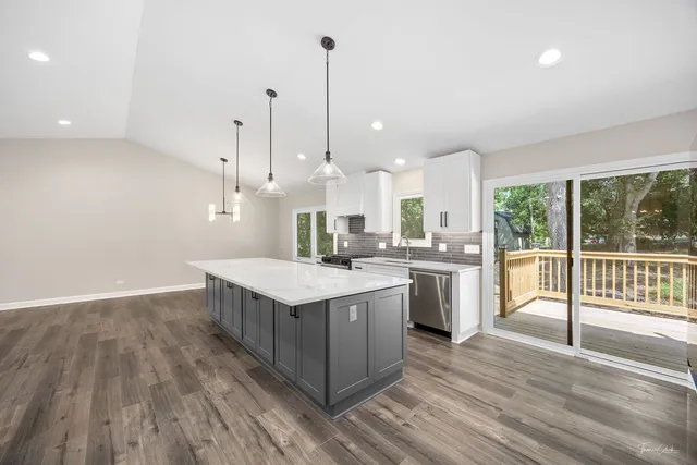 a view of a kitchen with a sink wooden floor and a window