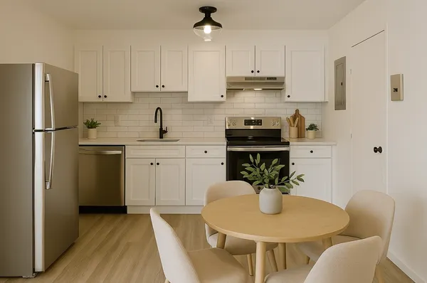 a kitchen with stainless steel appliances granite countertop white cabinets a refrigerator a sink a stove a dining table and chairs