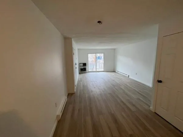 a view of a room with wooden floor and window