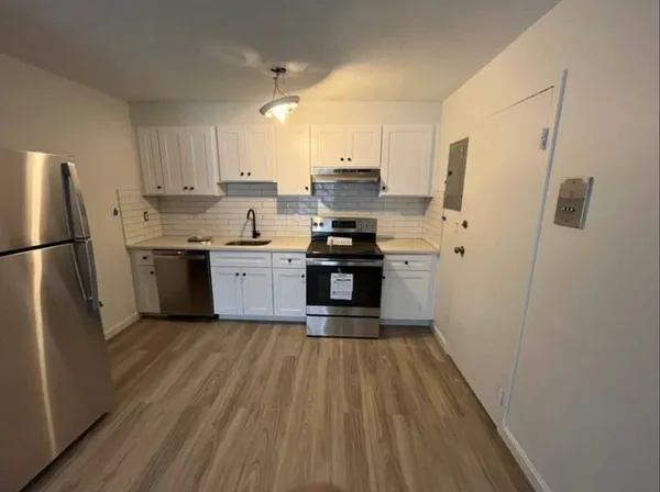 a kitchen with stainless steel appliances a refrigerator and a stove top oven