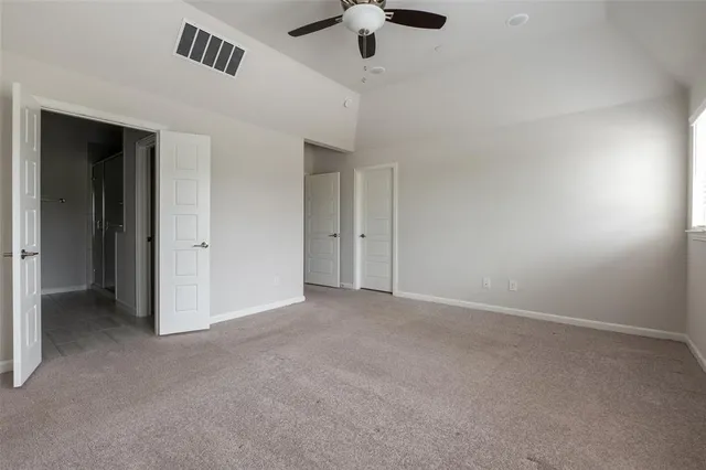 an empty room with fan & windows