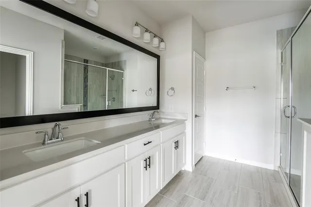 a bathroom with a double vanity sink and mirror