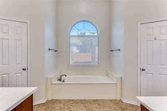 a bathroom with a granite countertop sink a mirror and a bathtub