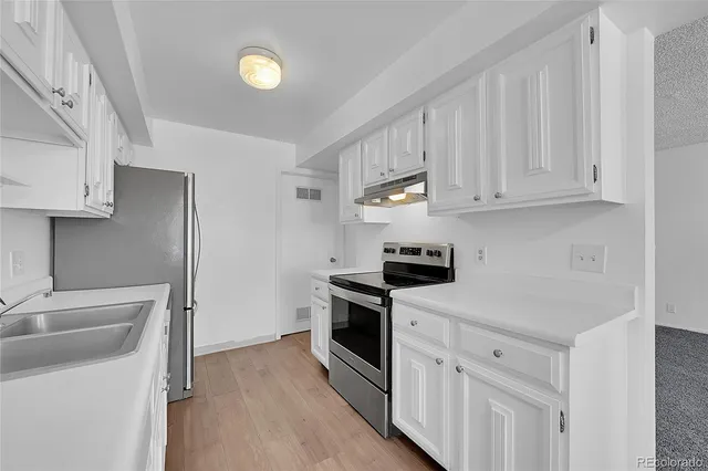 a kitchen with white cabinets and stainless steel appliances