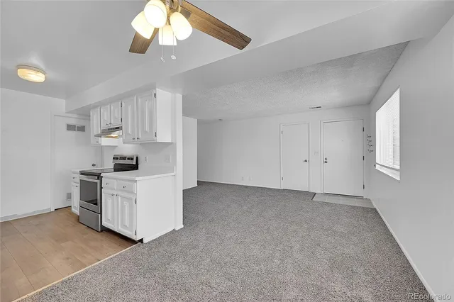 a kitchen with cabinets stainless steel appliances and a chandelier