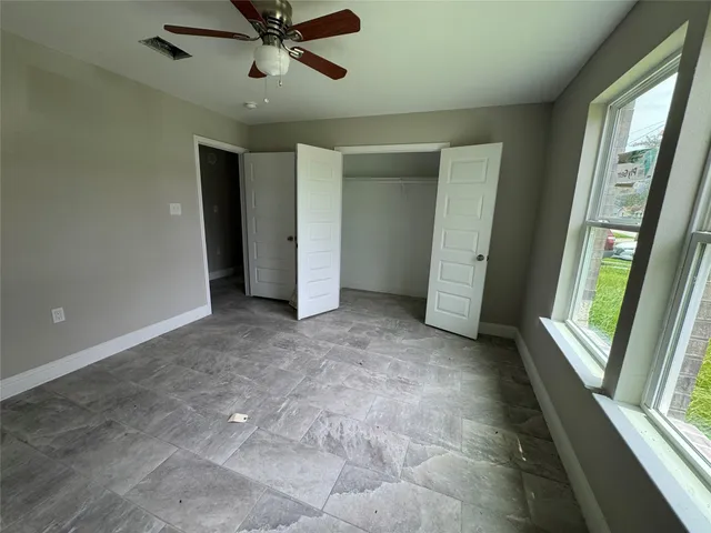 a view of a livingroom with a ceiling fan and window