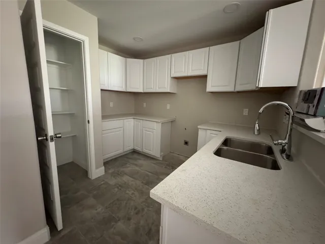 a kitchen with a sink a refrigerator and cabinets