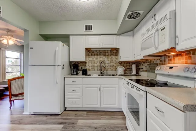 a kitchen with a white cabinets and refrigerator