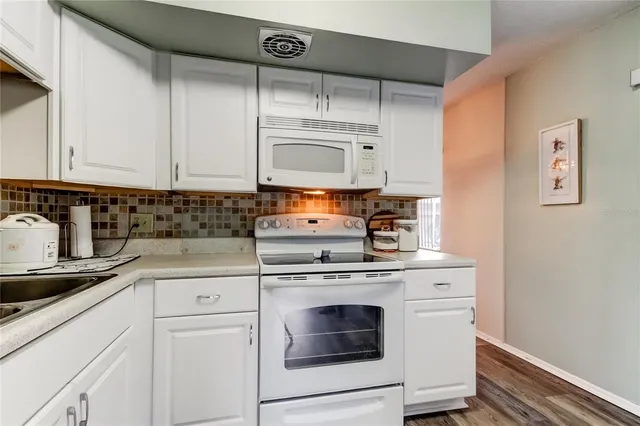 a kitchen with cabinets appliances and a sink