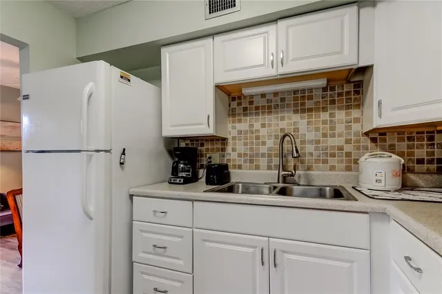 a kitchen with stainless steel appliances a refrigerator and cabinets