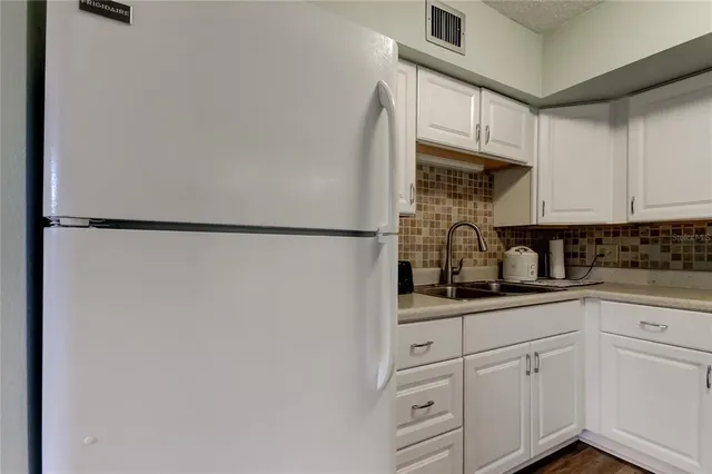 a kitchen with white cabinets and white appliances