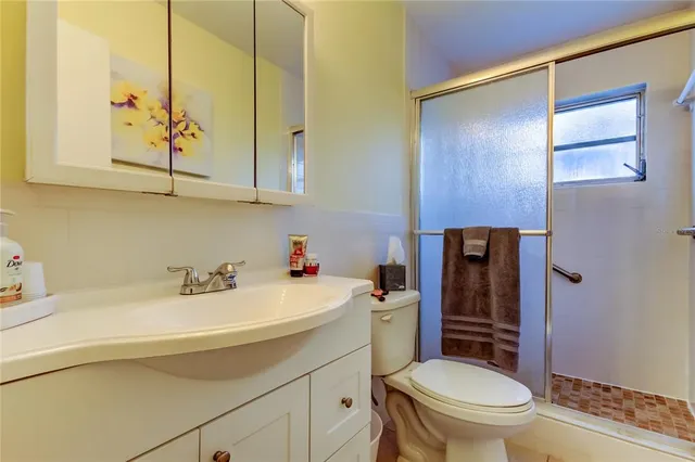 a bathroom with a sink a toilet and shower